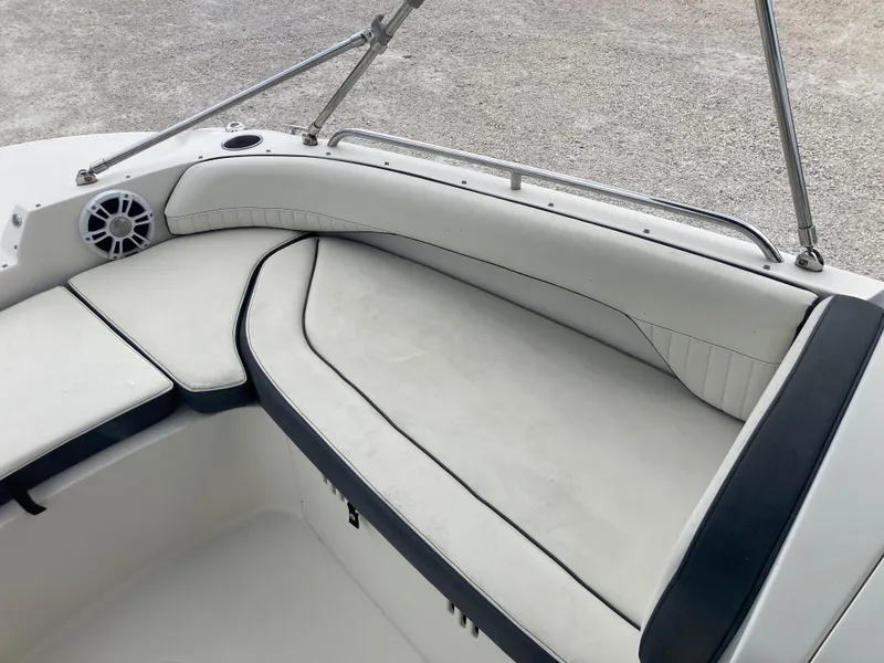 Slide: The Image of 2020 Stingray 212 boat interior with white cushioned seating and speaker. - 10