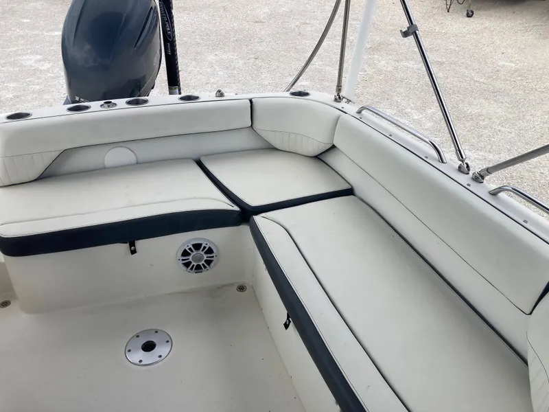 Slide: The Image of 2020 Stingray 212 boat interior with white cushioned seating and speaker. - 13