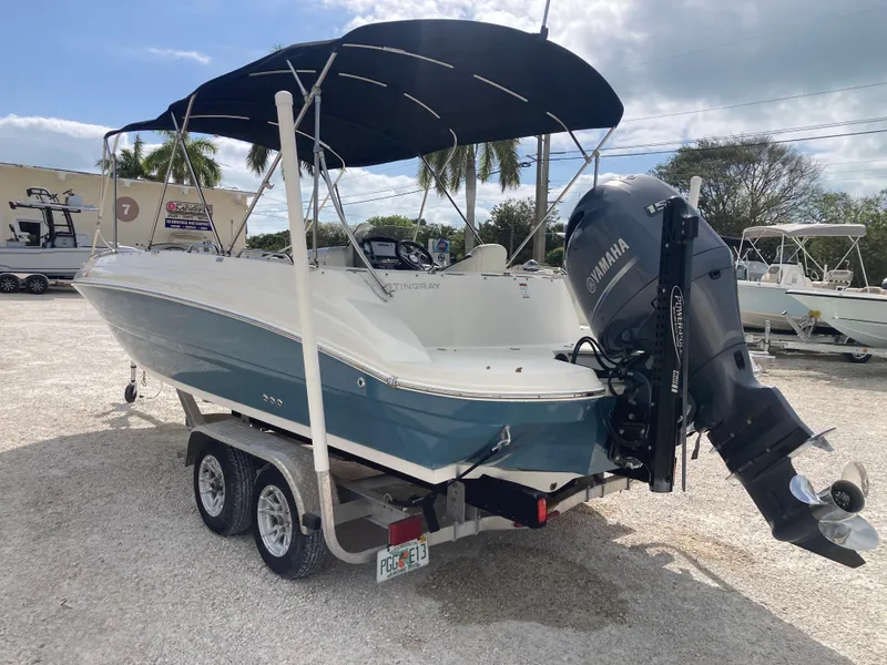 Slide: The Image of 2020 Stingray 212 boat with Yamaha outboard motor on trailer, parked outdoors. - 4