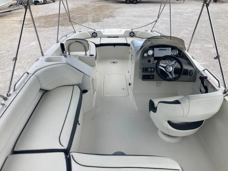 Slide: The Image of 2020 Stingray 212 boat interior with white seating and steering console. - 6