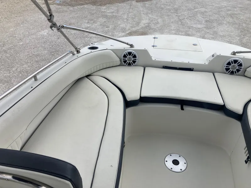 Slide: The Image of 2020 Stingray 212 boat interior with white cushioned seating and speakers. - 9