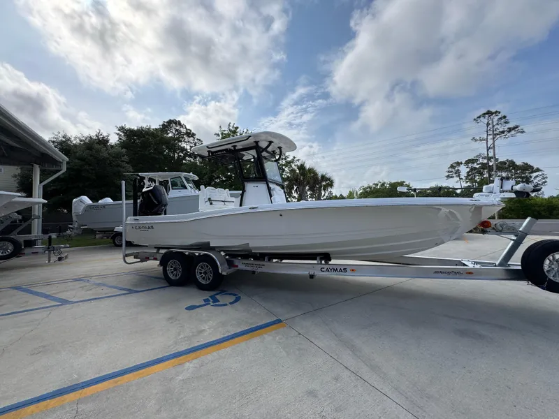 Slide: The Image of 2025 Caymas 28 HB boat on trailer, parked outdoors under cloudy sky. - 10