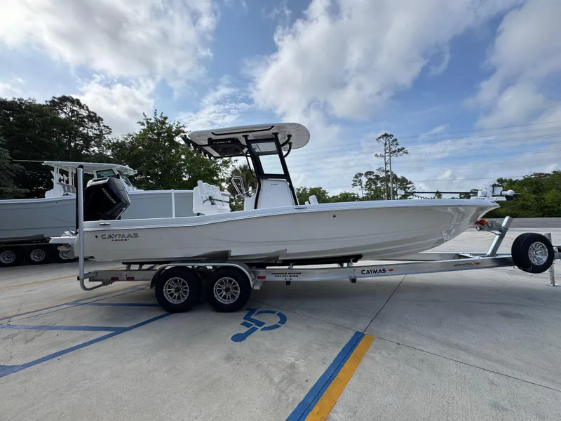 Slide: The Image of 2025 Caymas 28 HB boat on trailer, parked outdoors under a cloudy sky. - 11