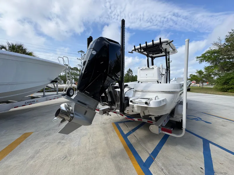 Slide: The Image of 2025 Caymas 28 HB boat with powerful outboard motor, parked on a trailer. - 15