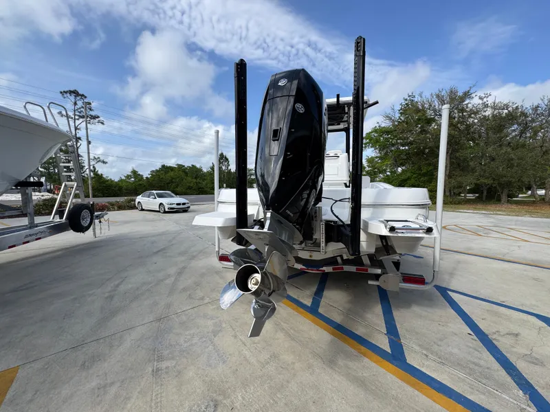 Slide: The Image of 2025 Caymas 28 HB boat with powerful outboard motor, parked on a concrete lot. - 16