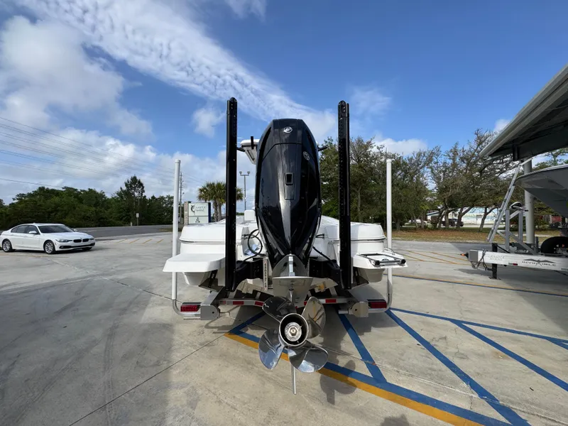 Slide: The Image of 2025 Caymas 28 HB boat with powerful outboard motor, parked on a sunny day. - 17