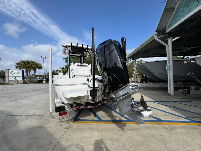 Slide: The Image of 2025 Caymas 28 HB boat with powerful outboard motor in a parking area. - 18