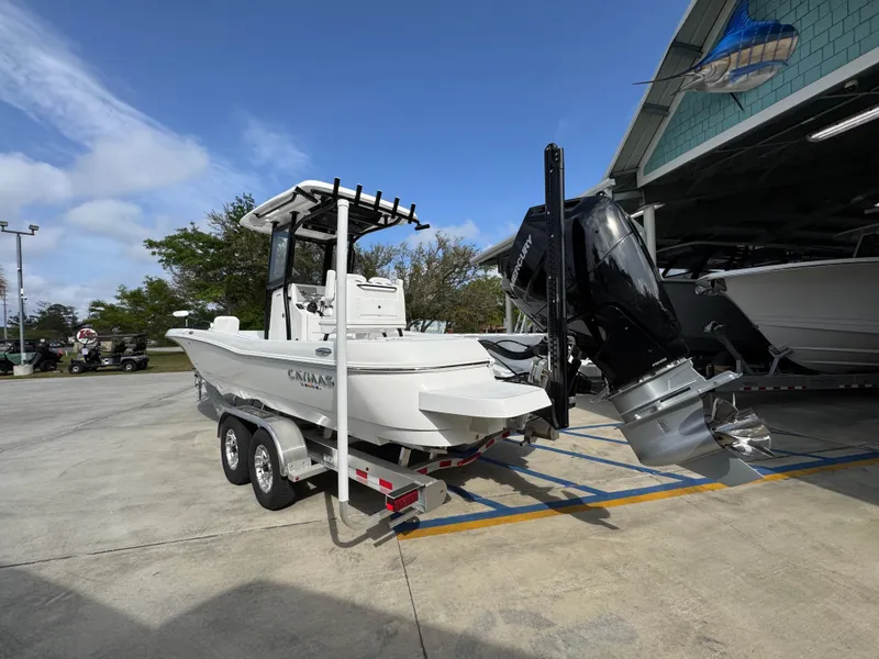 Slide: The Image of 2025 Caymas 28 HB boat on trailer, parked outdoors near a building. - 19