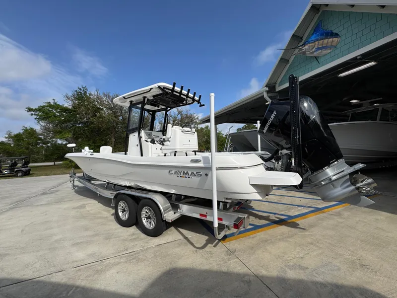 Slide: The Image of 2025 Caymas 28 HB boat on trailer, parked outdoors near a building. - 20