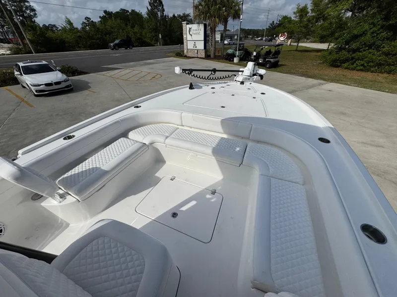 Slide: The Image of 2025 Caymas 28 HB boat with spacious seating and sleek design in a parking lot. - 21