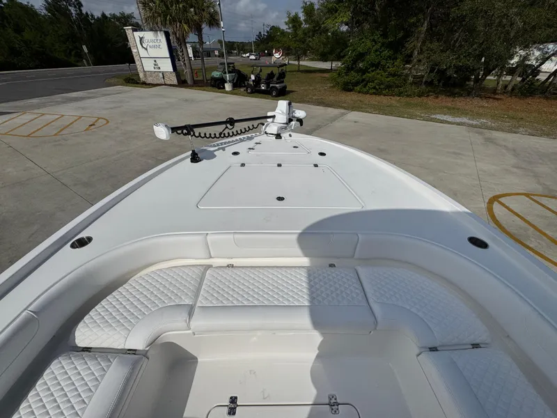 Slide: The Image of 2025 Caymas 28 HB boat with spacious seating and modern design, parked outdoors. - 22