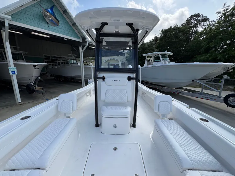 Slide: The Image of 2025 Caymas 28 HB boat interior with white seating, docked near other boats. - 27