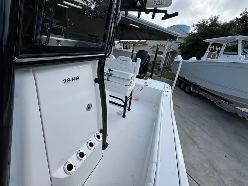 Slide: The Image of 2025 Caymas 28 HB boat, sleek design, docked outdoors. - 29