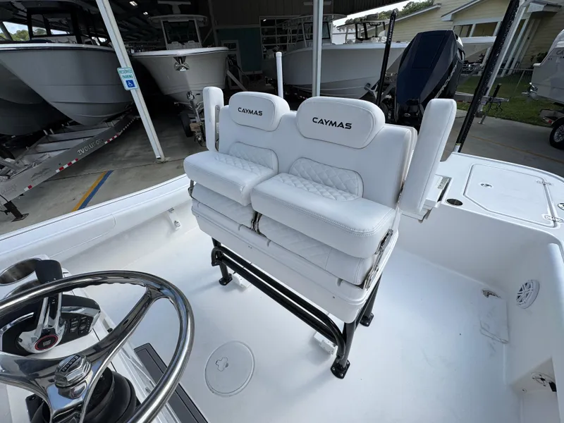 Slide: The Image of 2025 Caymas 28 HB boat interior with dual white seats and steering wheel. - 33