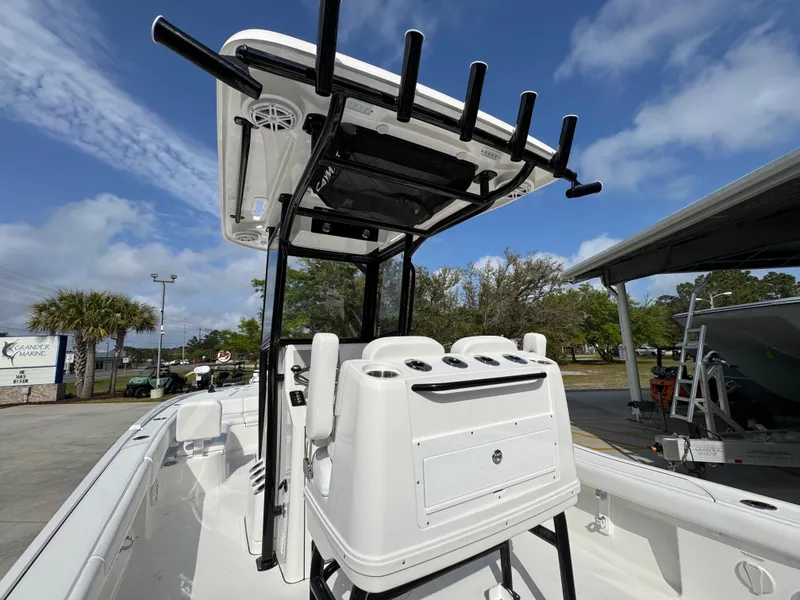 Slide: The Image of 2025 Caymas 28 HB boat with T-top and rod holders, parked outdoors under a blue sky. - 39