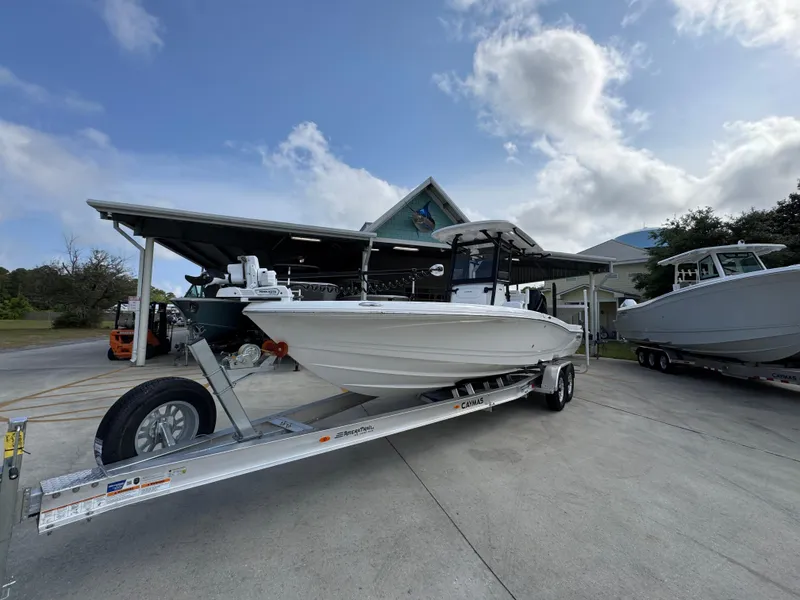 Slide: The Image of 2025 Caymas 28 HB boat on trailer, parked outdoors under a cloudy sky. - 4