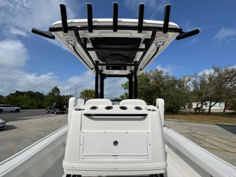 Slide: The Image of 2025 Caymas 28 HB boat with T-top and rod holders, parked outdoors. - 40