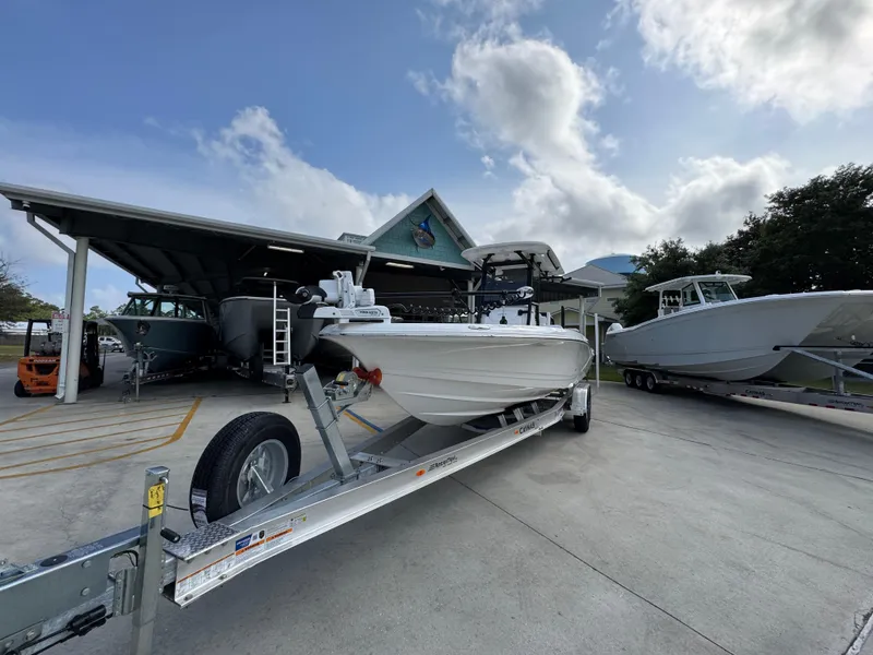 Slide: The Image of 2025 Caymas 28 HB boat on trailer, parked outdoors under a cloudy sky. - 5