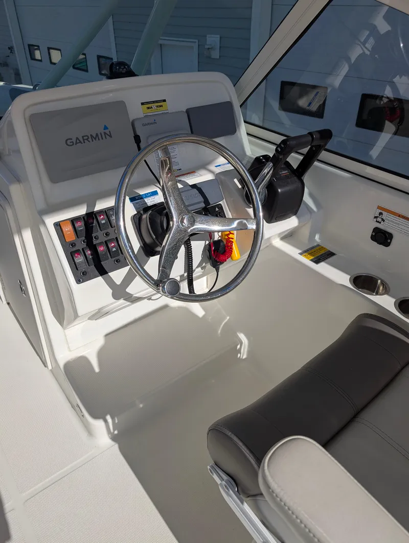 Slide: The Image of 2018 World Cat 230DC boat helm with Garmin navigation system and steering wheel. - 13