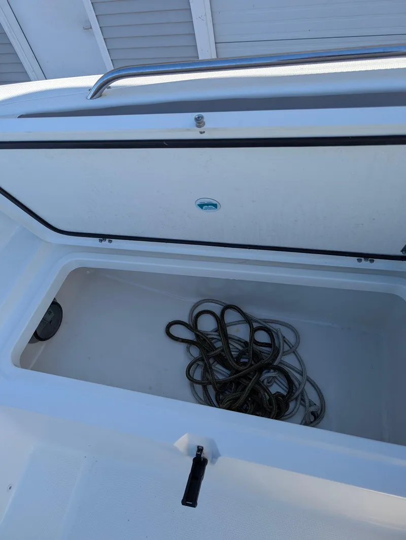 Slide: The Image of Open storage compartment on 2018 World Cat 230DC boat with coiled rope inside. - 17