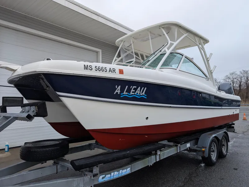 Slide: The Image of 2018 World Cat 230DC boat on trailer, side view, with "A L'EAU" text. - 2