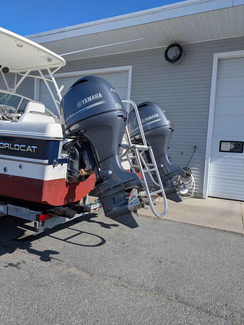Slide: The Image of 2018 World Cat 230DC boat with dual Yamaha outboard motors parked near a garage. - 28