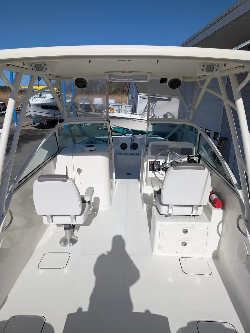 Slide: The Image of 2018 World Cat 230DC boat interior with dual consoles and seating under a canopy. - 3