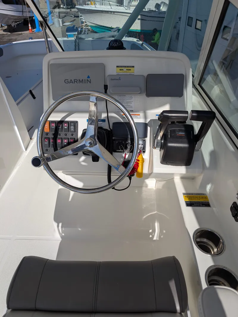 Slide: The Image of 2018 World Cat 230DC boat helm with Garmin navigation system and steering wheel. - 5