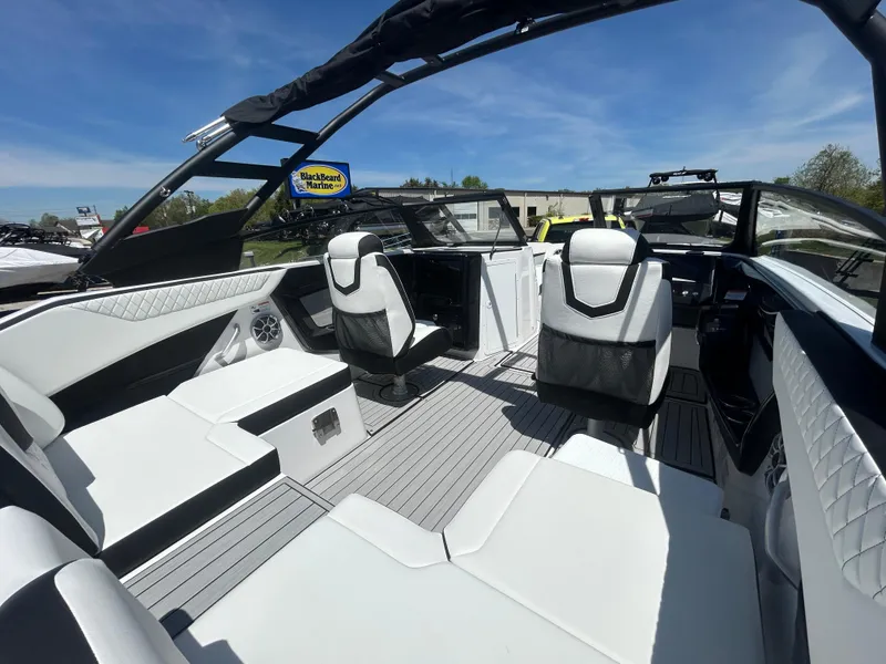 Slide: The Image of 2025 Yamaha Boats 222S interior with sleek white seating and modern design under a clear blue sky. - 7