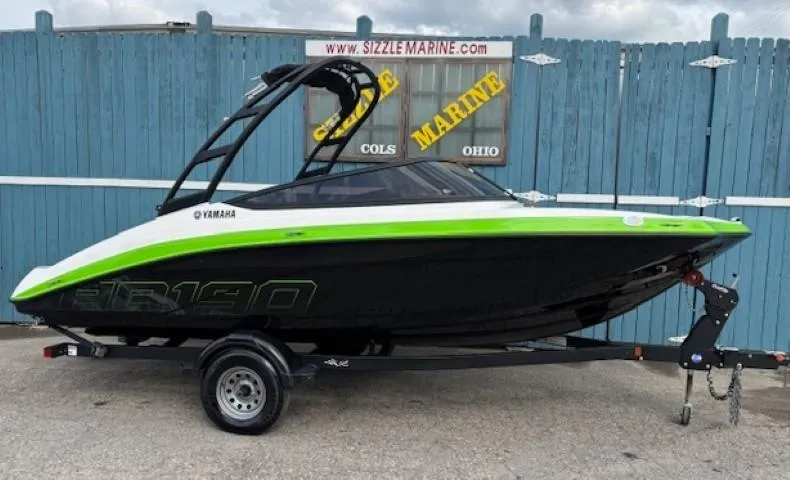 The Image of 2022 Yamaha AR190 boat with green accents on a trailer, displayed outdoors. - 0