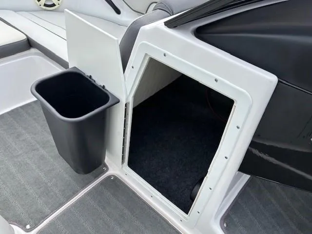 Slide: The Image of 2022 Yamaha AR190 boat interior with storage compartment and trash bin. - 18