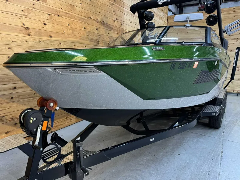 Slide: The Image of 2023 Malibu 25 LSV boat with green and silver exterior on a trailer. - 3