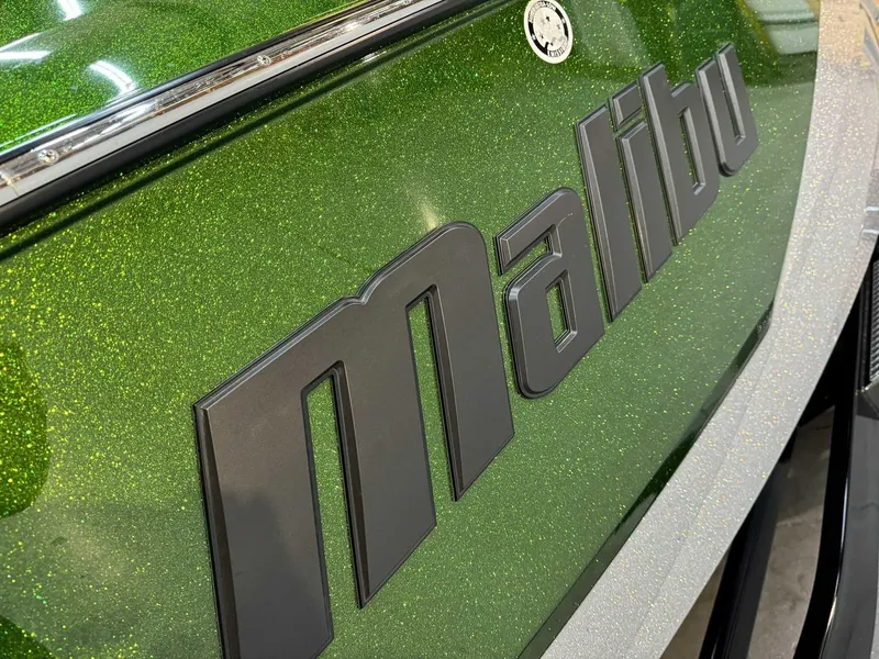 Slide: The Image of 2023 Malibu 25 LSV boat with metallic green finish and bold logo. - 4