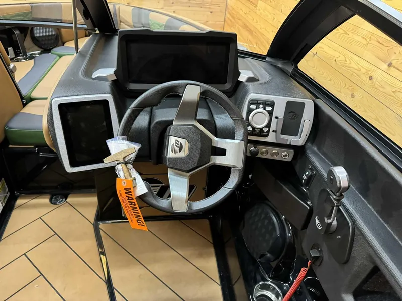 Slide: The Image of 2023 Malibu 25 LSV boat dashboard with modern steering and digital controls. - 6
