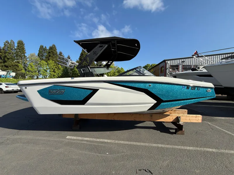 Slide: The Image of 2023 Heyday WT-2DC boat with blue and white design, parked outdoors on a wooden stand. - 1