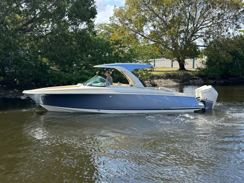 Slide: The Image of 2025 Chris-Craft Launch GT 31 boat cruising on a calm river, surrounded by trees. - 16