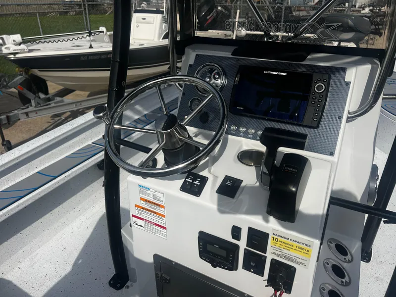 Slide: The Image of 2023 Xpress X23B Lounge boat console with steering wheel and navigation controls. - 15