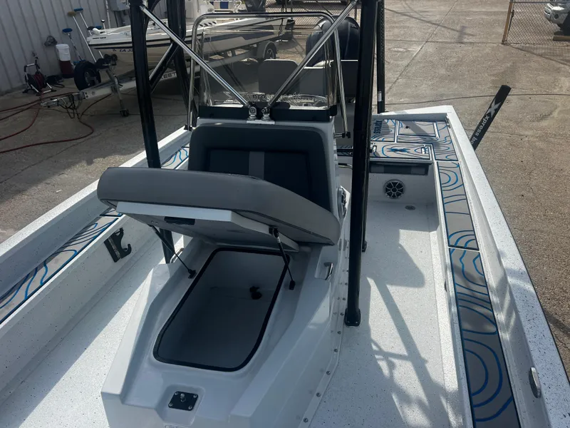 Slide: The Image of 2023 Xpress X23B Lounge boat interior with open storage compartment and seating. - 8