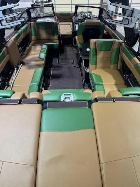 Slide: The Image of 2022 Malibu M240 boat interior with green and tan seating, modern dashboard, and spacious layout. - 4