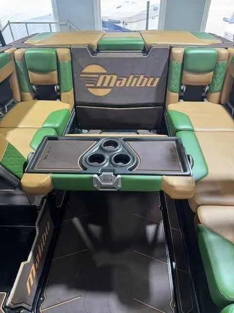Slide: The Image of Interior of 2022 Malibu M240 boat with green and tan seating and cup holders. - 6
