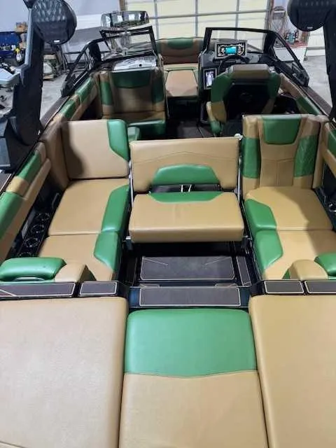 Slide: The Image of 2022 Malibu M240 boat interior with green and tan seating, featuring modern design and spacious layout. - 7