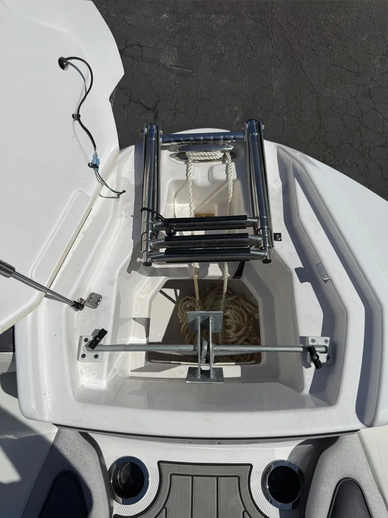 Slide: The Image of 2022 Yamaha Boats 252SD anchor compartment with ladder and rope storage. - 16
