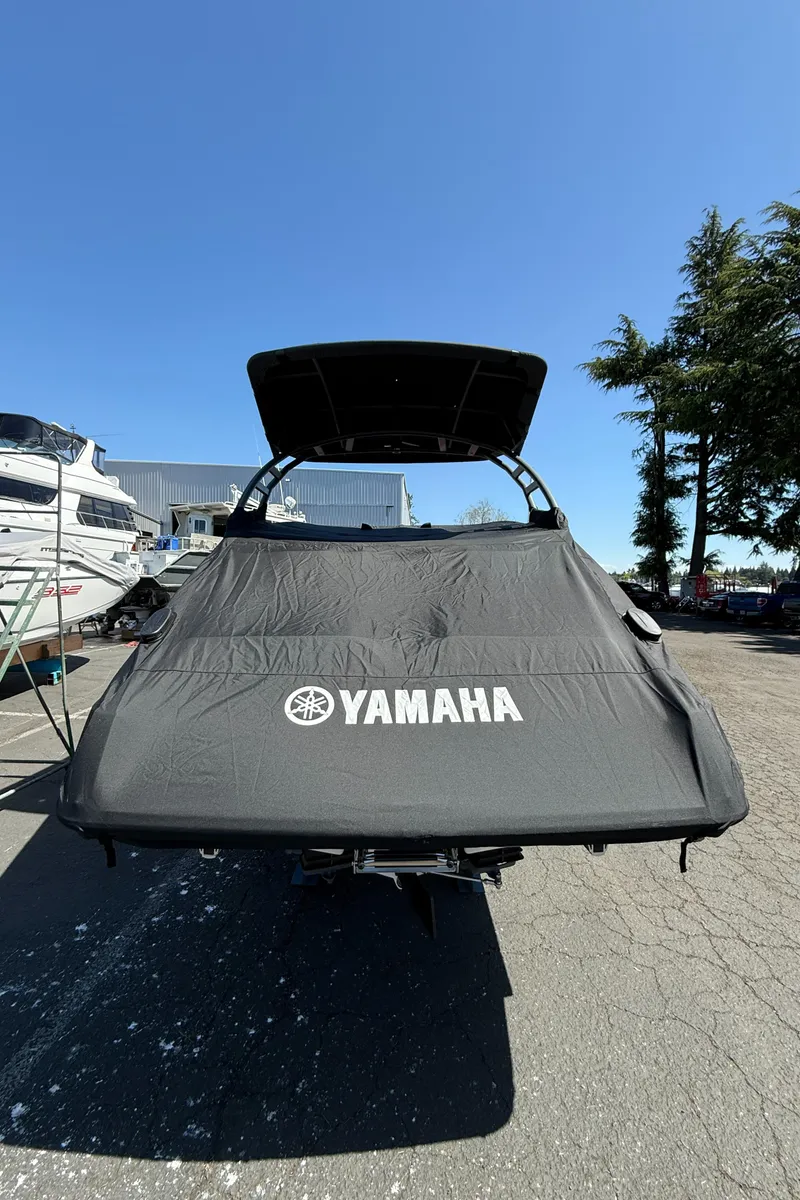 Slide: The Image of 2022 Yamaha Boats 252SD with cover, parked outdoors under clear blue sky. - 5