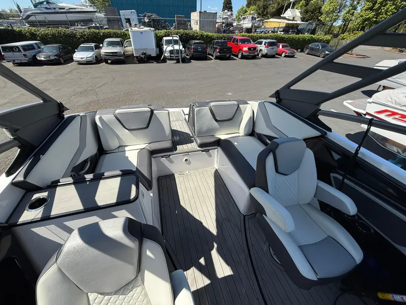Slide: The Image of 2022 Yamaha Boats 252SD interior with modern seating and sleek design in a parking lot setting. - 9