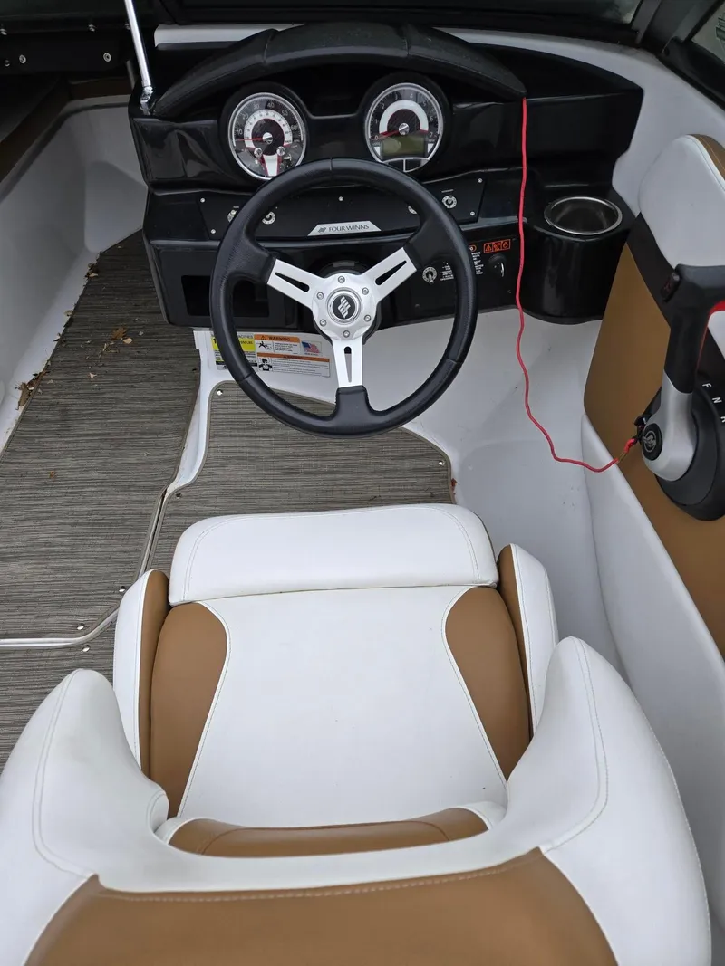 Slide: The Image of 2022 Four Winns HD2 I/O boat interior with steering wheel and dashboard. - 5