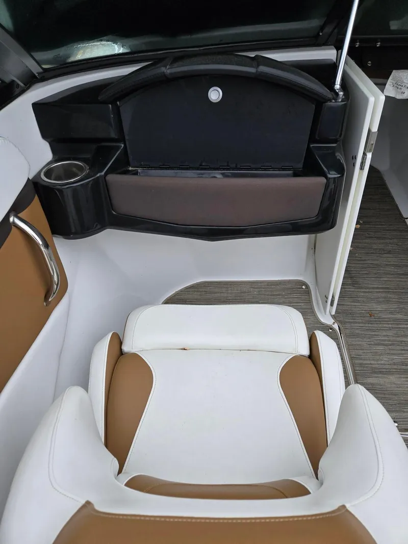 Slide: The Image of 2022 Four Winns HD2 I/O boat interior with white and tan seating, cup holder, and storage compartment. - 7