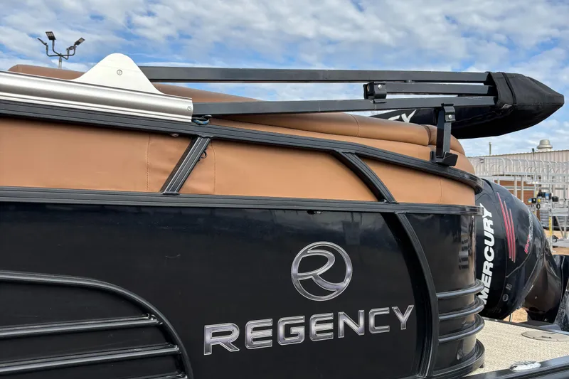 Slide: The Image of 2018 Regency R220LE3 boat with Mercury engine, featuring sleek black design and brown seating. - 3