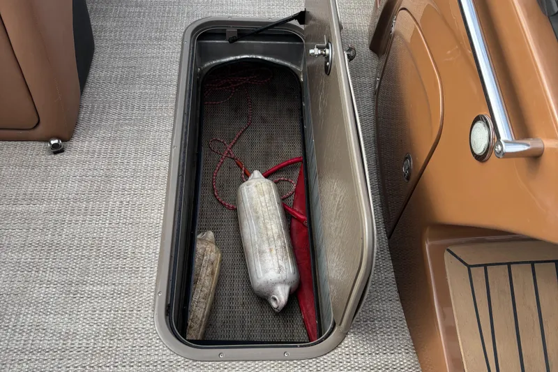 Slide: The Image of Open storage compartment on 2018 Regency R220LE3 boat with fenders and ropes inside. - 8