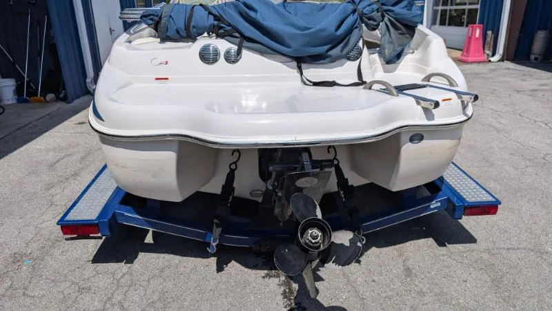 Slide: The Image of 2006 Tahoe Q4 boat on trailer, covered, with visible propeller and rear view. - 4