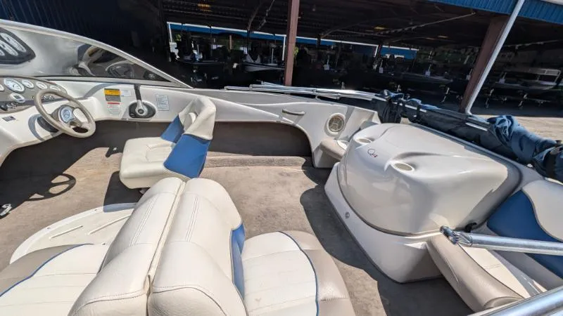 Slide: The Image of 2006 Tahoe Q4 boat interior with beige and blue seating, parked in a covered area. - 5